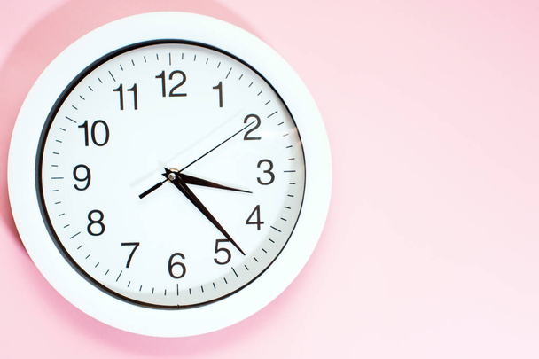Součást bílých nástěnných hodin. Detailní záběr plastových nástěnných hodin na růžovém pozadí s kopií prostoru. - Fotografie, Obrázek