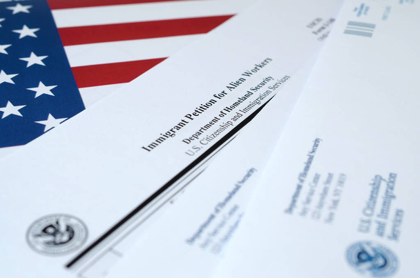 I-140 Immigrantenpetitie voor buitenaardse werknemers blanco formulier ligt op de vlag van de Verenigde Staten met enveloppe van het ministerie van Binnenlandse Veiligheid - Foto, afbeelding