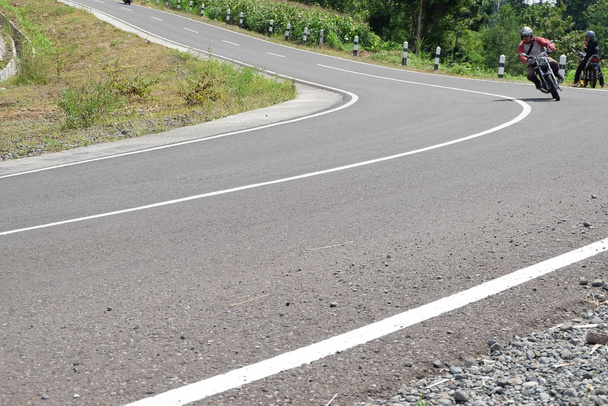 Ο άνθρωπος ιππασία μια κλασική μοτοσικλέτα στην εθνική οδό του βουνού - Φωτογραφία, εικόνα