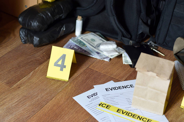 Evidence Chain of Custody Labels and brown paper bag lies with big heroin packets and packs of money bills as evidence in crime scene investigation process - Photo, Image