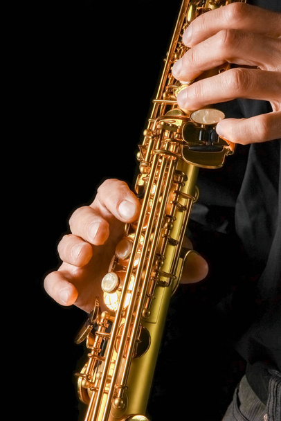soprano saxophone in hands on a black background - Photo, image