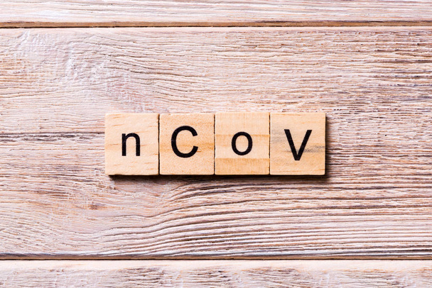 nCoV word written on wood block. nCoV text on wooden table for your desing, coronavirus concept top view - 写真・画像