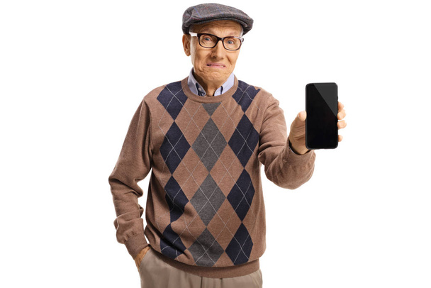 Elderly man holding a phone and making a sad face  - Foto, imagen