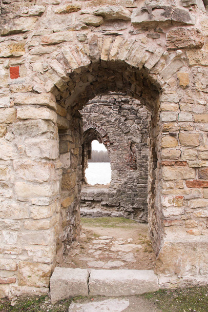 Portál ve středověké hradní zdi. Zeď z kamení a cihel s oknem uprostřed. Jeden z vchodů do zničeného hradu.. - Fotografie, Obrázek