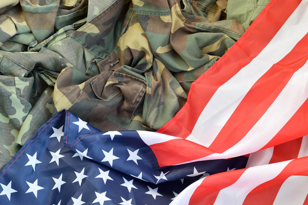 Yhdysvallat lippu ja taitettu sotilaallinen yhtenäinen takki. Armeijan symbolit käsitteellinen tausta banneri Amerikan isänmaallinen vapaapäivät
 - Valokuva, kuva