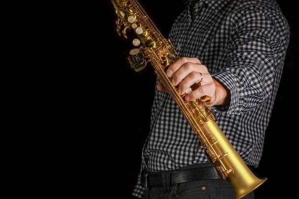 soprano saxophone in hands on a black background - Foto, Imagem