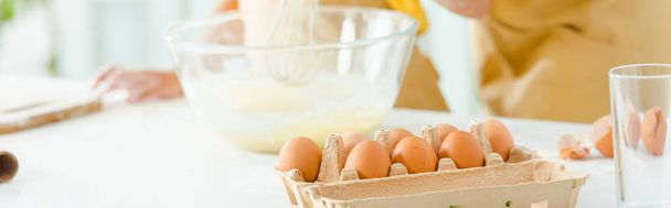 panoramic shot of eggs near african american kid and mother - Foto, imagen