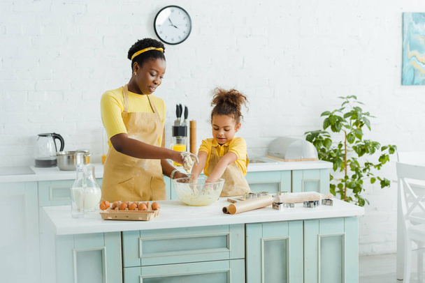 cheerful african american mother and daughter kneading dough in kitchen  - Photo, Image