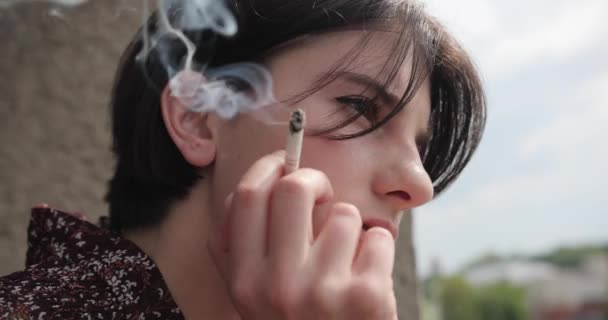 Close up view of young beautiful brunette woman smoking cigarette at home. 4k, Slowmotion. - Metraje, vídeo