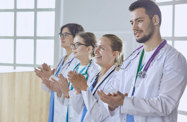 Счастливая команда врачей, состоящая из мужчин и женщин, широко улыбается и дает большой палец вверх успеха и надежды - Фото, изображение