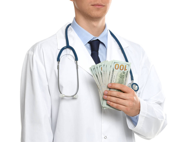 Doctor with bribe on white background, closeup. Corruption in me - Photo, image
