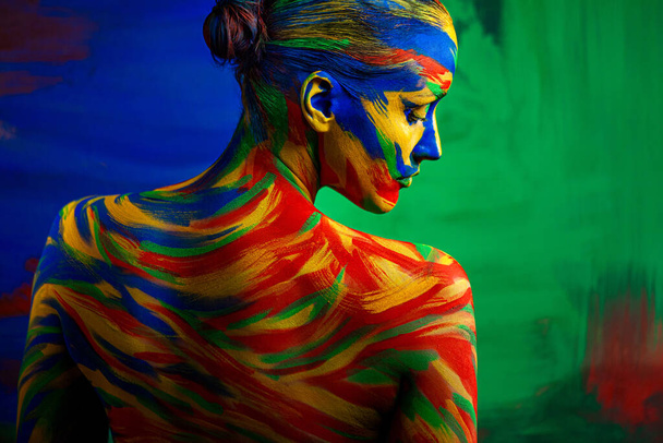 Art fashion makeup. Color face of woman for inspiration. Abstract portrait of the bright beautiful girl with colorful make-up and bodyart. - 写真・画像