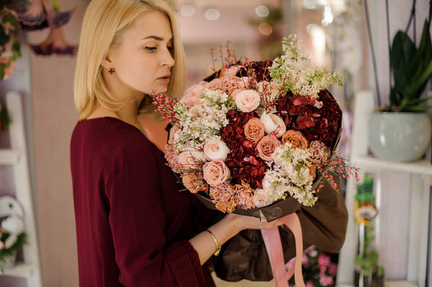 Happy female holding rich and lush bouquet - Photo, Image