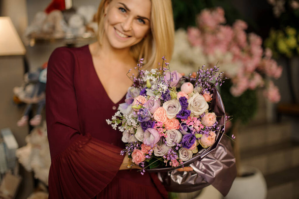 Blonde with short hair standing with bouquet - Foto, afbeelding