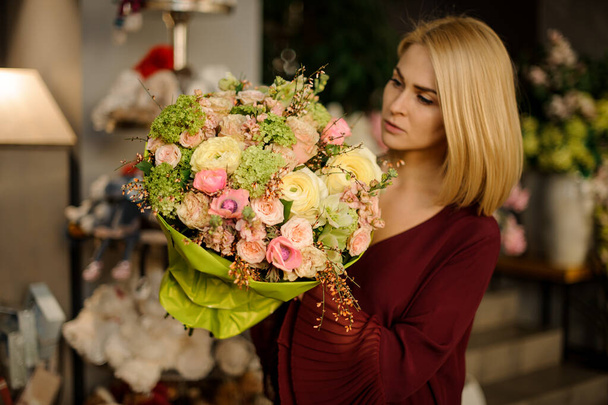 Well dressed woman looking at flower bouquet - Valokuva, kuva