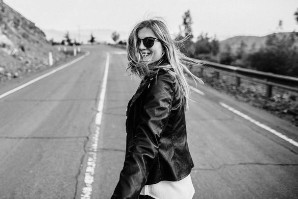 Beautiful happy girl in leather jacket on road - Φωτογραφία, εικόνα