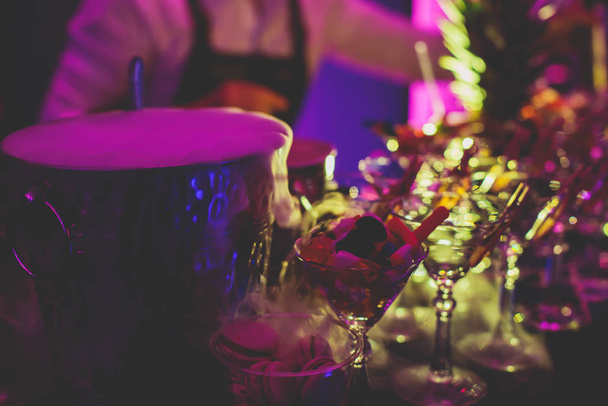 Vue du cadre de l'alcool sur la table de banquet de restauration, ligne de rangée de différents cocktails alcoolisés colorés sur une fête, martini, vodka, et d'autres sur la table de bouquet de restauration décorée événement
  - Photo, image