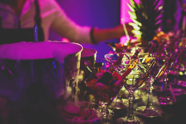 Vista dell'impostazione dell'alcol sul tavolo da banchetto di catering, linea di fila di cocktail alcolici colorati diversi su una festa, martini, vodka e altri eventi decorati sul tavolo del bouquet di catering
  - Foto, immagini