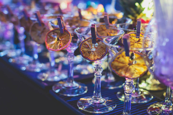 View of alcohol setting on catering banquet table, row line of different colored alcohol cocktails on a party, martini, vodka, and others on decorated catering bouquet table event  - Photo, image