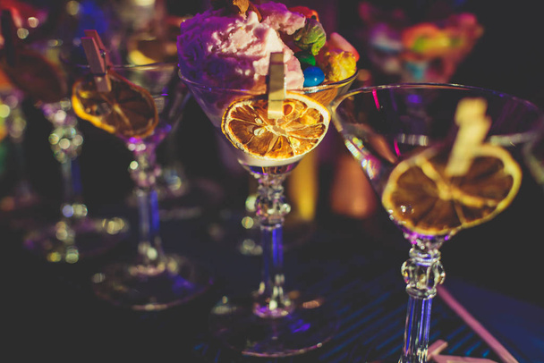View of alcohol setting on catering banquet table, row line of different colored alcohol cocktails on a party, martini, vodka, and others on decorated catering bouquet table event  - Foto, immagini