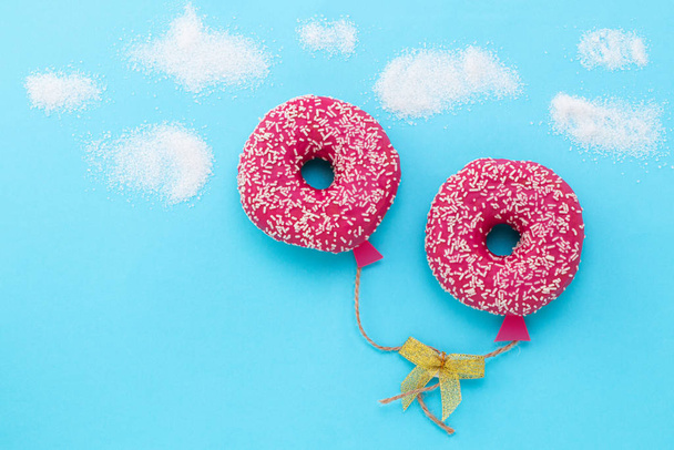 Creative food minimalism. Donut on blue background, donut in a s - Photo, Image