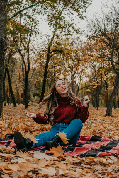 Осеннее настроение. Осенний портрет брюнетки с длинными вьющимися волосами. Молодая красивая случайная радостная женщина, развлекающаяся в парке осеннего города
 - Фото, изображение