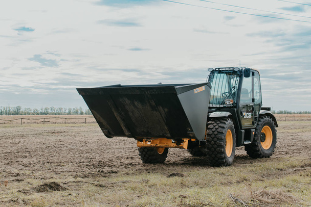 The JCB bucket loader, Tractor at a demonstration site agro exhibition AgroExpo. Tractor rides on the field. Kropivnitskiy, Ukraine April 20, 2019. - 写真・画像
