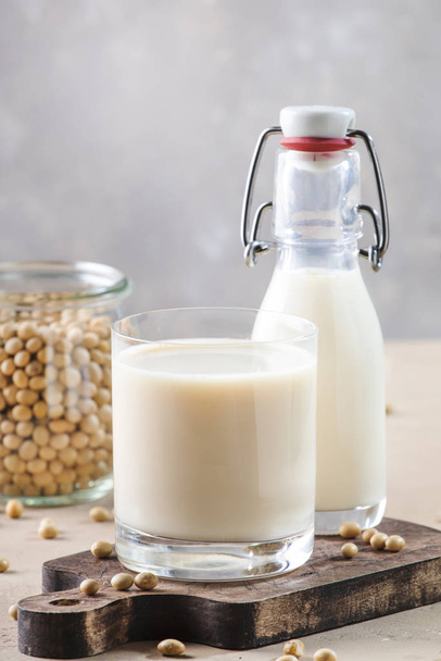 Soy milk and soy bean on gray table. Non-dairy milk concept. Vegan drink. Copy space - Φωτογραφία, εικόνα
