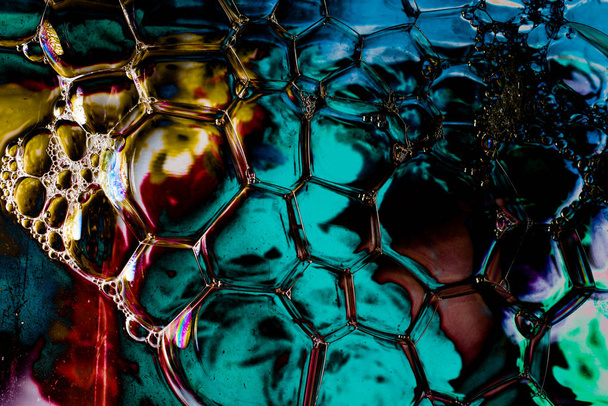 Macro-opname van water olie-emulsie over gekleurde achtergrond - Foto, afbeelding