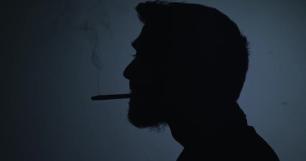 Silhouette άνθρωπος κάπνισμα τσιγάρο σε μπλε φόντο - Πλάνα, βίντεο