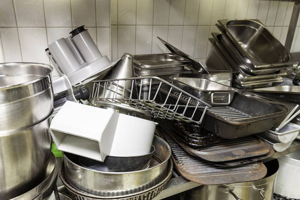 Pila de viejas bandejas para hornear en una cocina industrial
 - Foto, Imagen