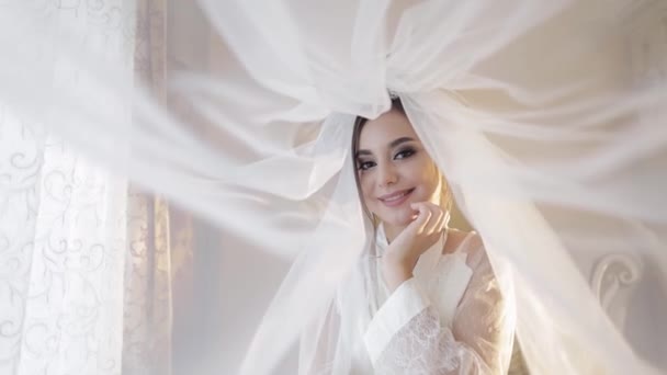 Mooie en mooie bruid in nachtjapon onder de sluier. Huwelijksdag - Video