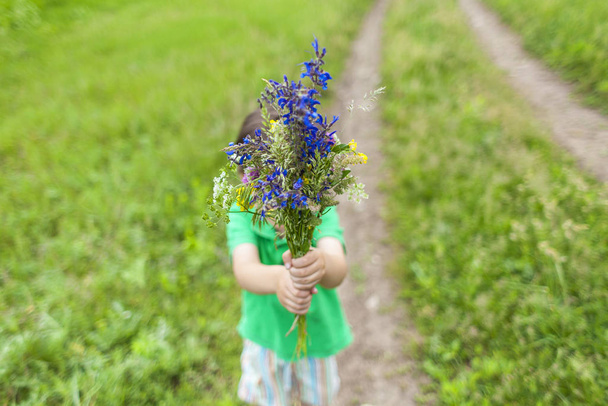 Le garçon tend un bouquet
. - Photo, image