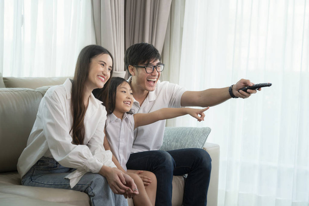 Asiático família desfrutar de olhar lcd tv no sofá na sala de estar
 - Foto, Imagem