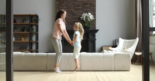 Joyful mommy dancing jumping with cute small daughter. - Video