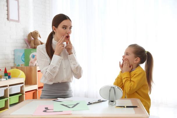 Speech therapist working with little girl in office - Foto, imagen