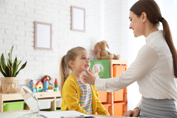 Speech therapist working with little girl in office - Фото, изображение
