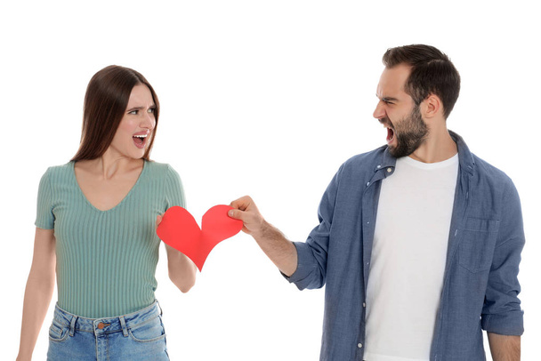 Couple tearing paper heart on white background. Relationship problems - 写真・画像