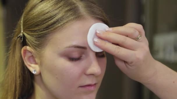Professionele make-up artiest behandelt een klant gezicht met een wattenstaafje. - Video