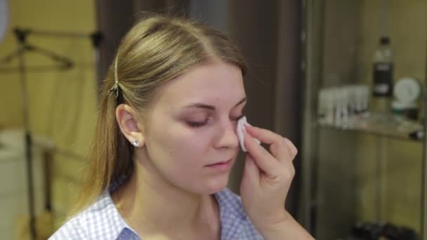 Professional makeup artist treats a clients face with a cotton swab. - Footage, Video
