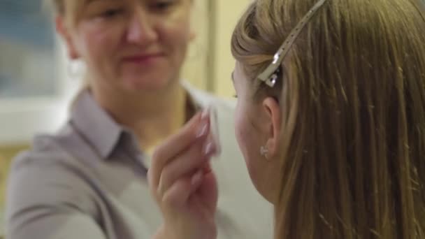 Professionele make-up artiest behandelt een klant gezicht met een wattenstaafje. - Video