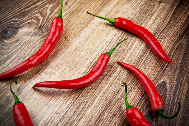 Organic chili peppers on wooden background - Zdjęcie, obraz