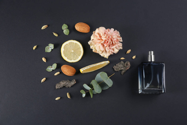 Composição flat lay com garrafa de perfume sobre fundo preto
 - Foto, Imagem