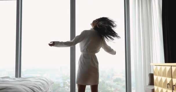 Przepełniona radością młoda kobieta bawiąca się po przebudzeniu rano. - Materiał filmowy, wideo