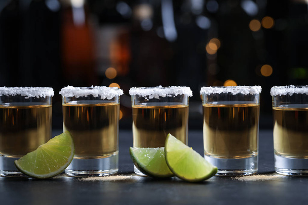 Mexican Tequila shots, lime slices and salt on bar counter - Foto, afbeelding
