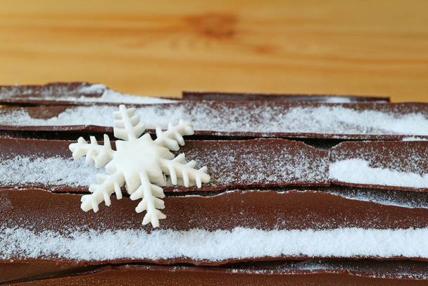 Uzavřený povrch čokoládové Yule Log Cake se sněhovou vločkou tvarovaný cukr dekorace na Vánoce, textura pozadí - Fotografie, Obrázek