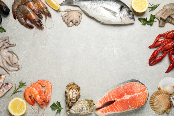 Fresh fish and seafood on light grey table, flat lay. Space for text - Photo, Image