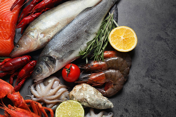 frischer Fisch und Meeresfrüchte auf grauem Tisch, flach gelegt - Foto, Bild