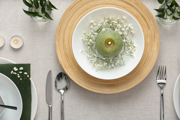 Elegant table setting with green plants on light cloth, flat lay - Fotó, kép