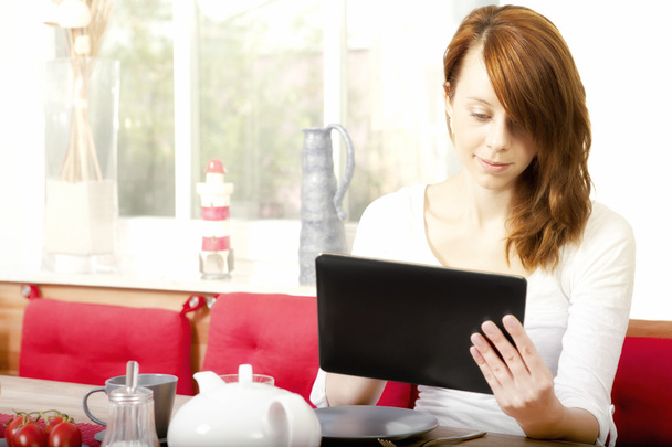 hübsche junge Frau surft auf ihrem Tablet-PC - Foto, Bild